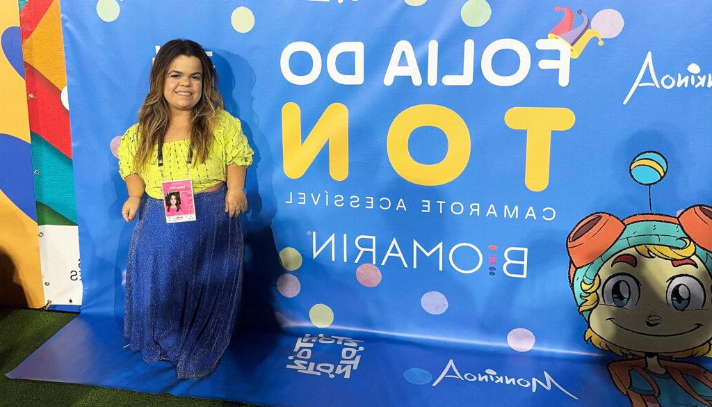 Rebeca Costa standing in front of a banner at Carnival